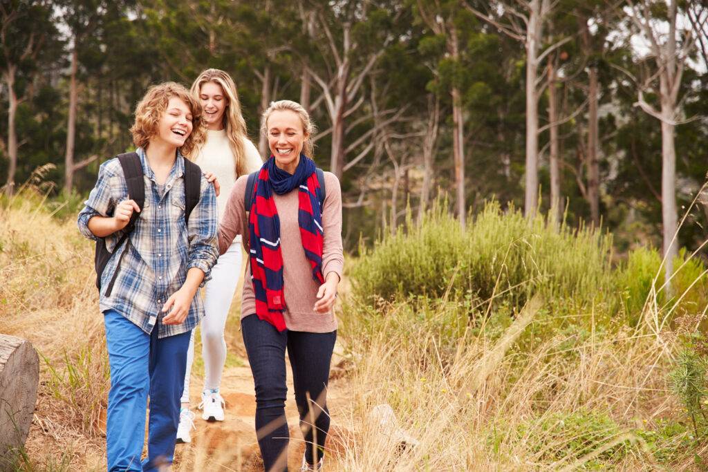 Liikkuminen lisää elämänlaatua tamoksifeenihoitojen aikana. Äiti ja teini-ikäiset lapset ulkoilevat iloisina yhdessä.